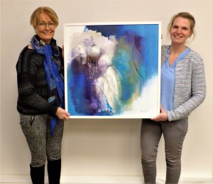 Anne Hirschel (links) mit der Geschäftsstellenleitern Melanie Sallermann und einem Werk aus  der laufenden Ausstellung